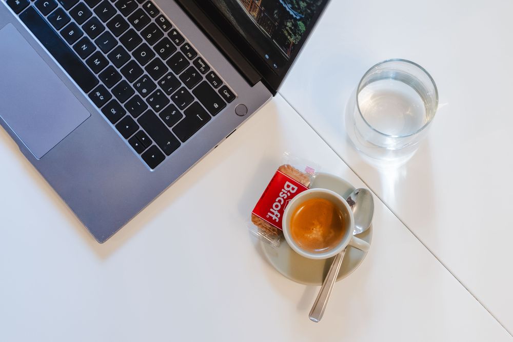 Caffè espresso con biscotto e bicchiere d'acqua sul tavolo