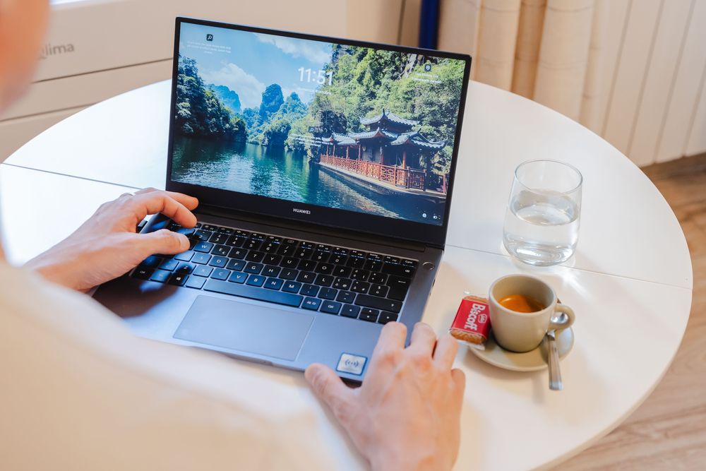 Un computer portatile sul tavolo con un caffè accanto