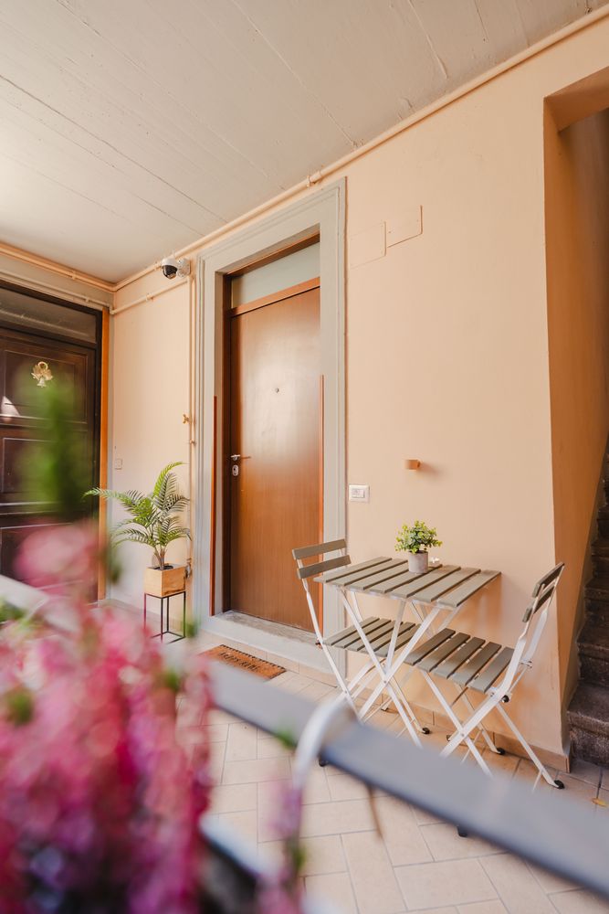 La porta d'ingresso dell'appartamento, con tavolino e due sedie